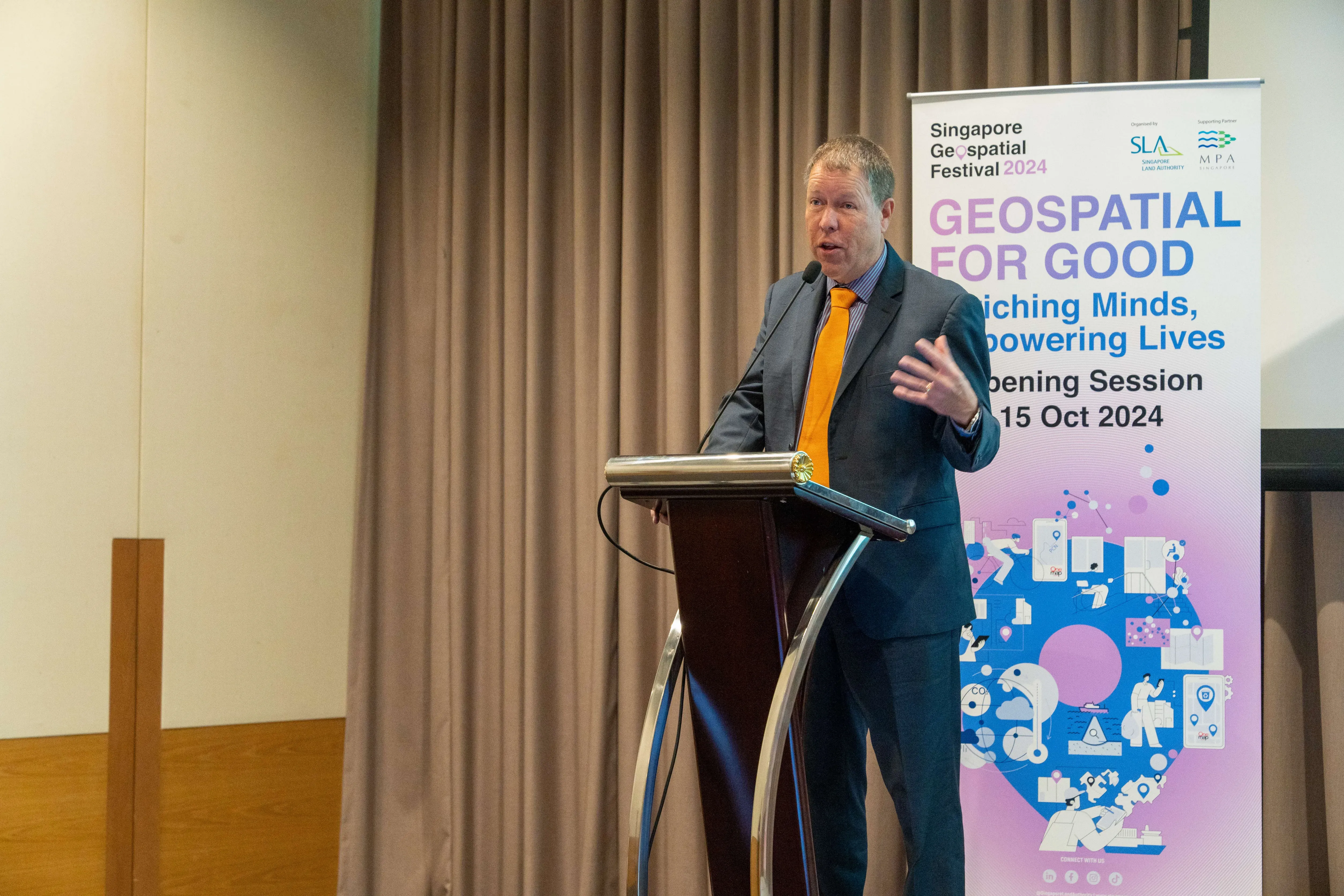 Mr Scott Simmons, Chief Standards Officer of Open Geospatial Consortium speaks at podium.